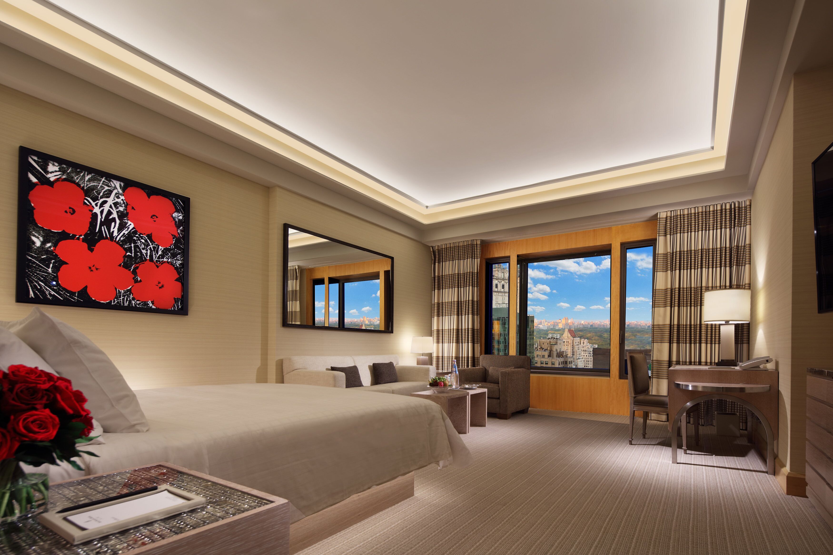 Une chambre d’hôtel avec un grand lit, un bureau, une chaise, une télévision et une vue sur la ville.