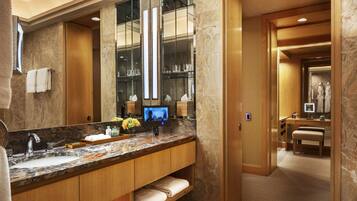 A modern bathroom with a large mirror, marble countertop, and a vanity with a sink.
