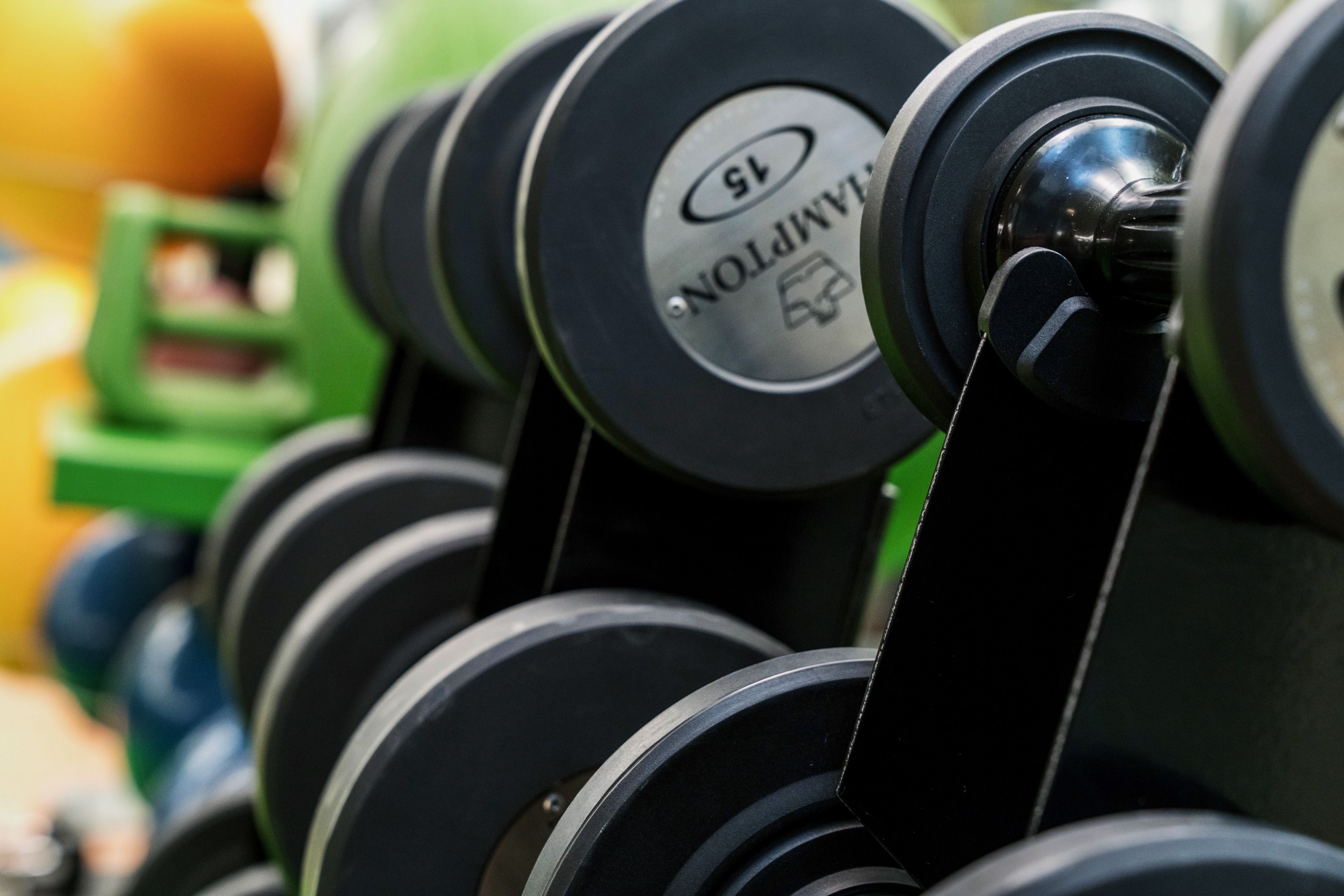 A close-up of a dumbbell rack with weights labeled '15'.