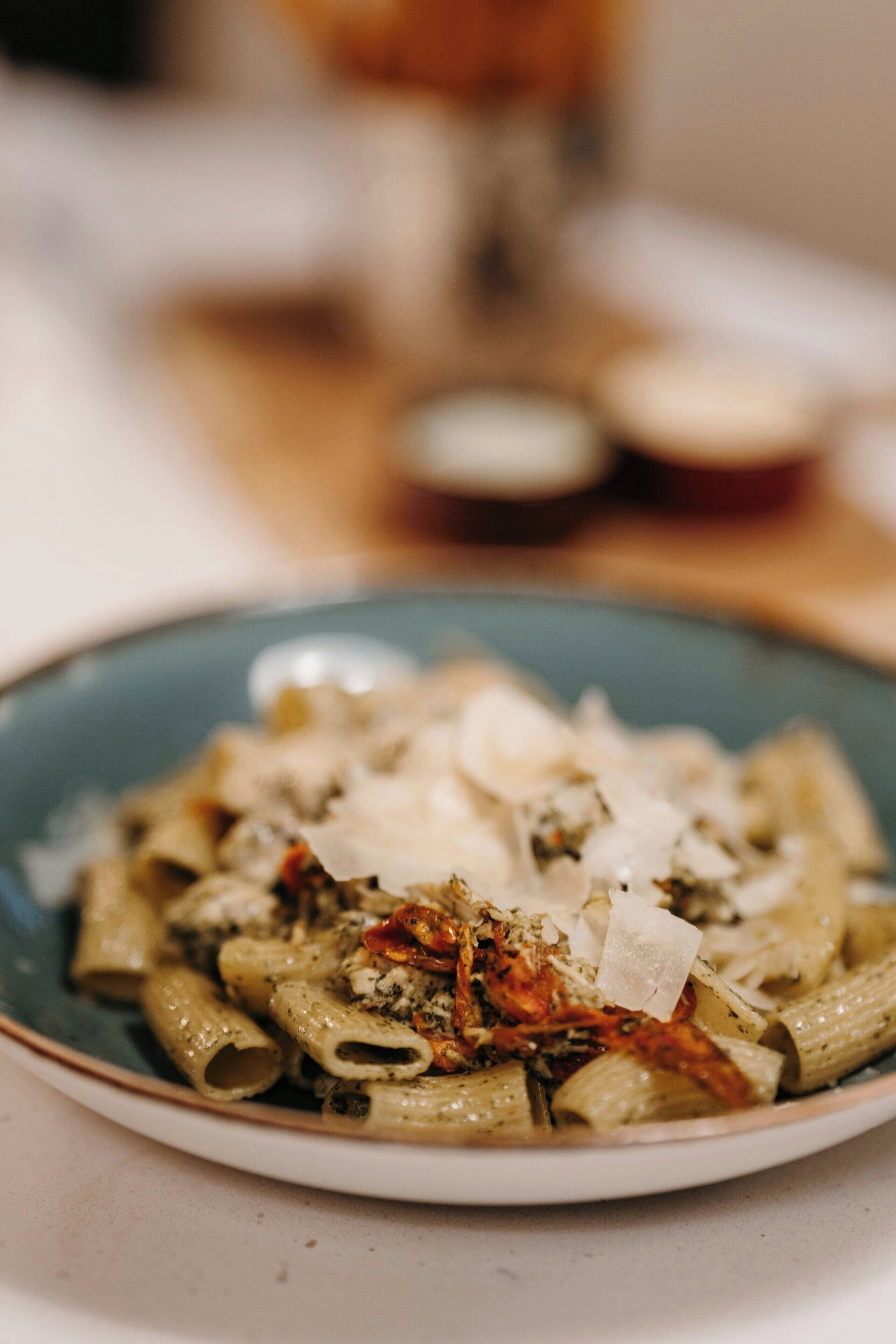 A plate of pasta with cheese and herbs.