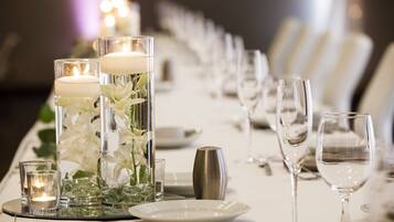 A table set for a formal event with candles, glassware, and floral arrangements.