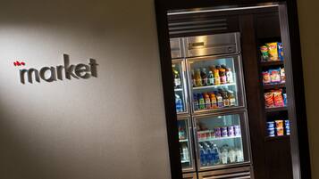 A wall with a 'market' sign and a refrigerator stocked with beverages and snacks.