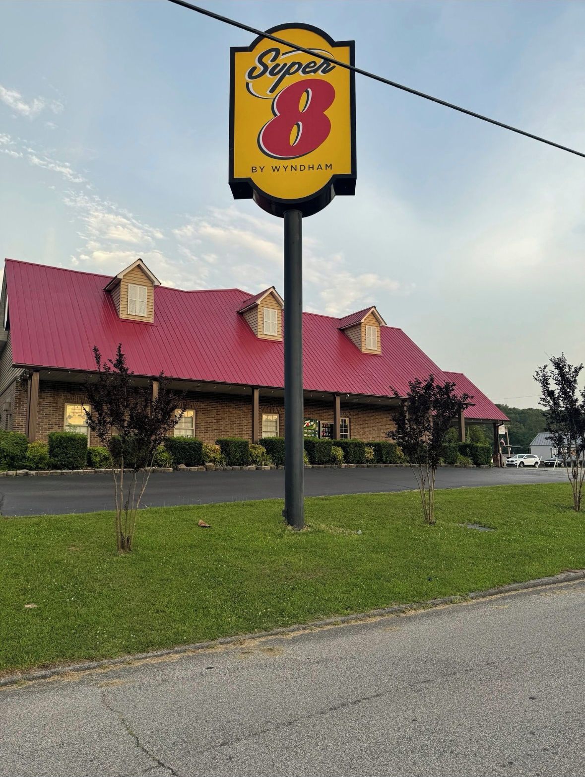 Un hotel Super 8 amb teulada vermella i façana de maó.