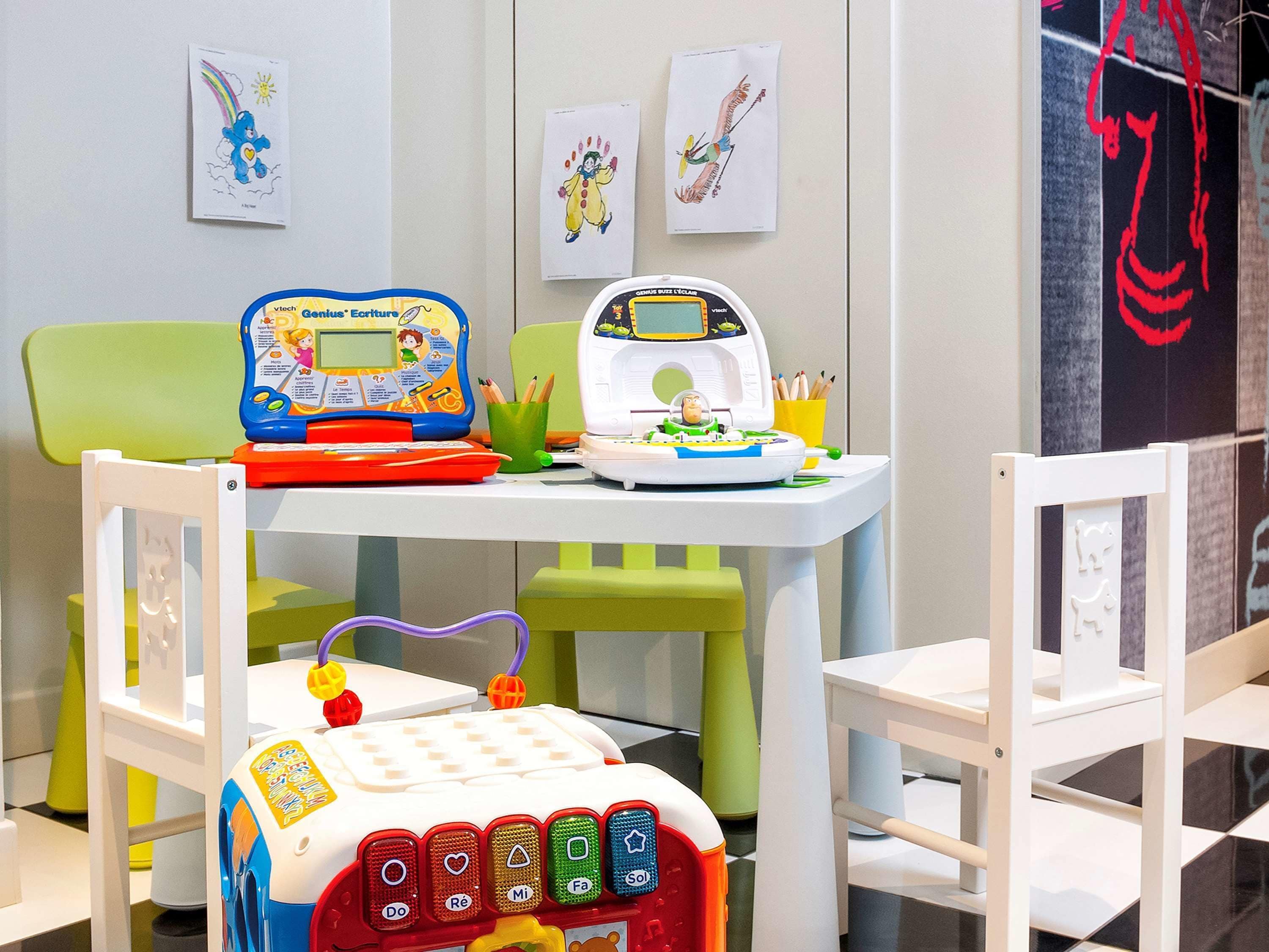 Un'area giochi per bambini con tavolo, sedie e giochi educativi.