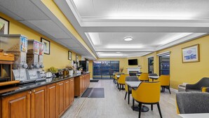 A modern restaurant with a counter, yellow chairs, and a large window. - Days Inn by Wyndham Salem (Salem)