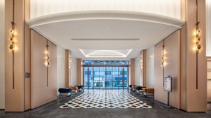 A hotel lobby with a patterned floor, seating area, and a view through the glass doors. - Holiday Inn Express Shenzhen Luohu Port by IHG (Shenzhen)