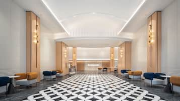 Um saguão moderno de hotel com piso estampado em padrão geométrico, áreas de estar e um balcão de recepção.