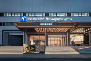 A modern hotel entrance with a covered walkway, large glass doors, and a sign indicating it's a Holiday Inn Express. - Holiday Inn Express Shenzhen Luohu Port by IHG (Shenzhen)