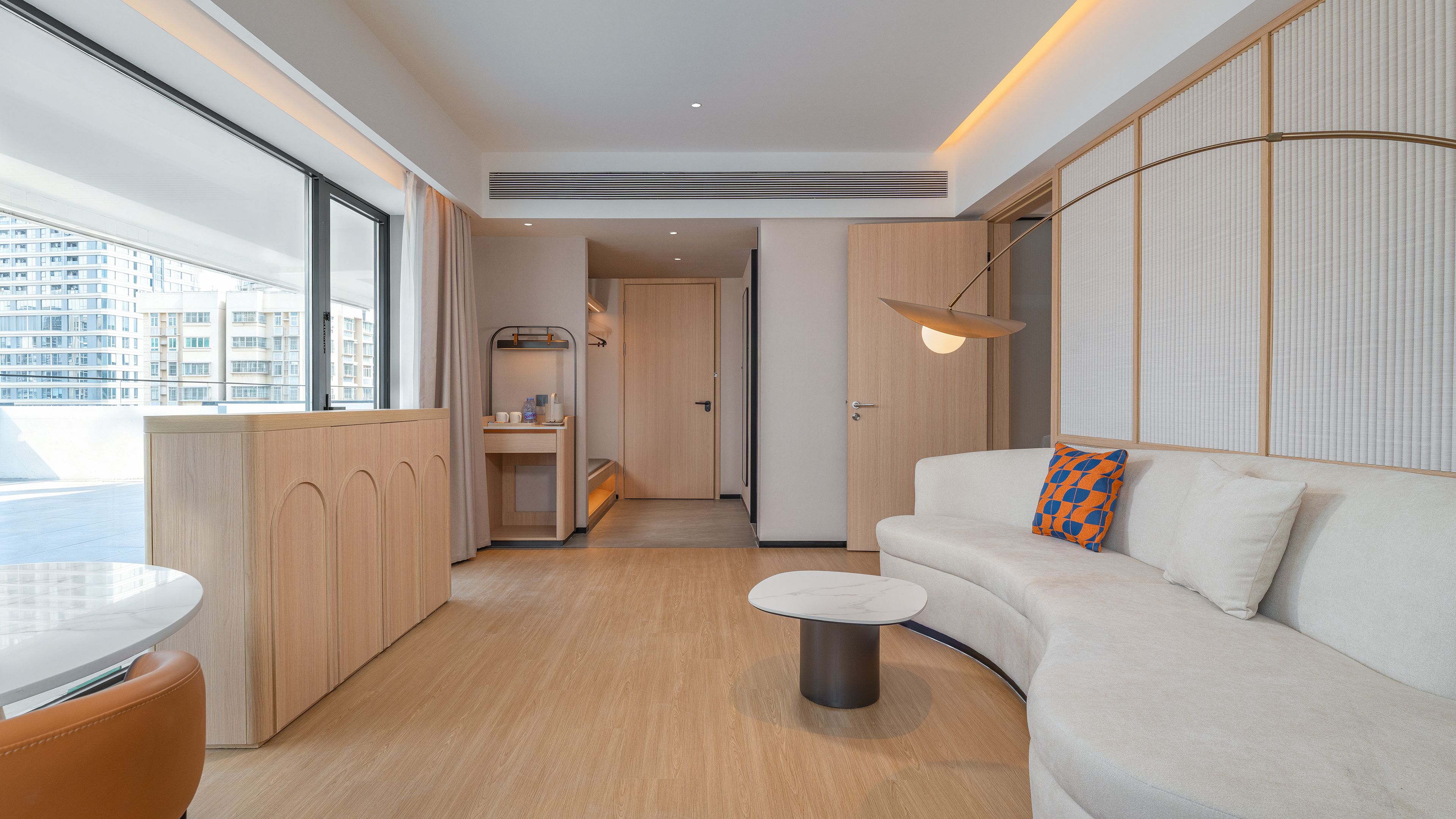 A modern interior with a sofa, a small table, and a view of the outside.