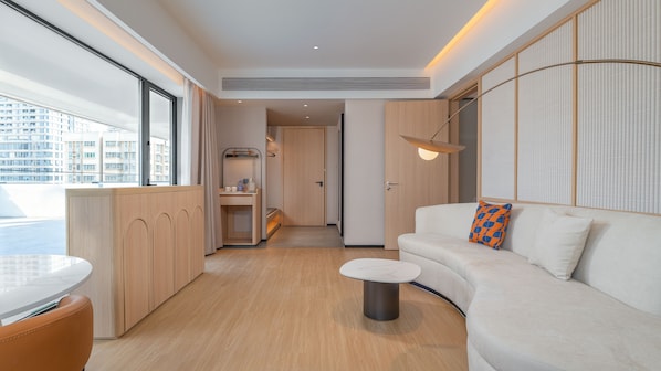A modern interior with a sofa, a small table, and a view of the outside. - Holiday Inn Express Shenzhen Luohu Port by IHG (Shenzhen)