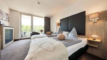 A modern hotel room with a large bed, a desk, a chair, and a balcony with a view.