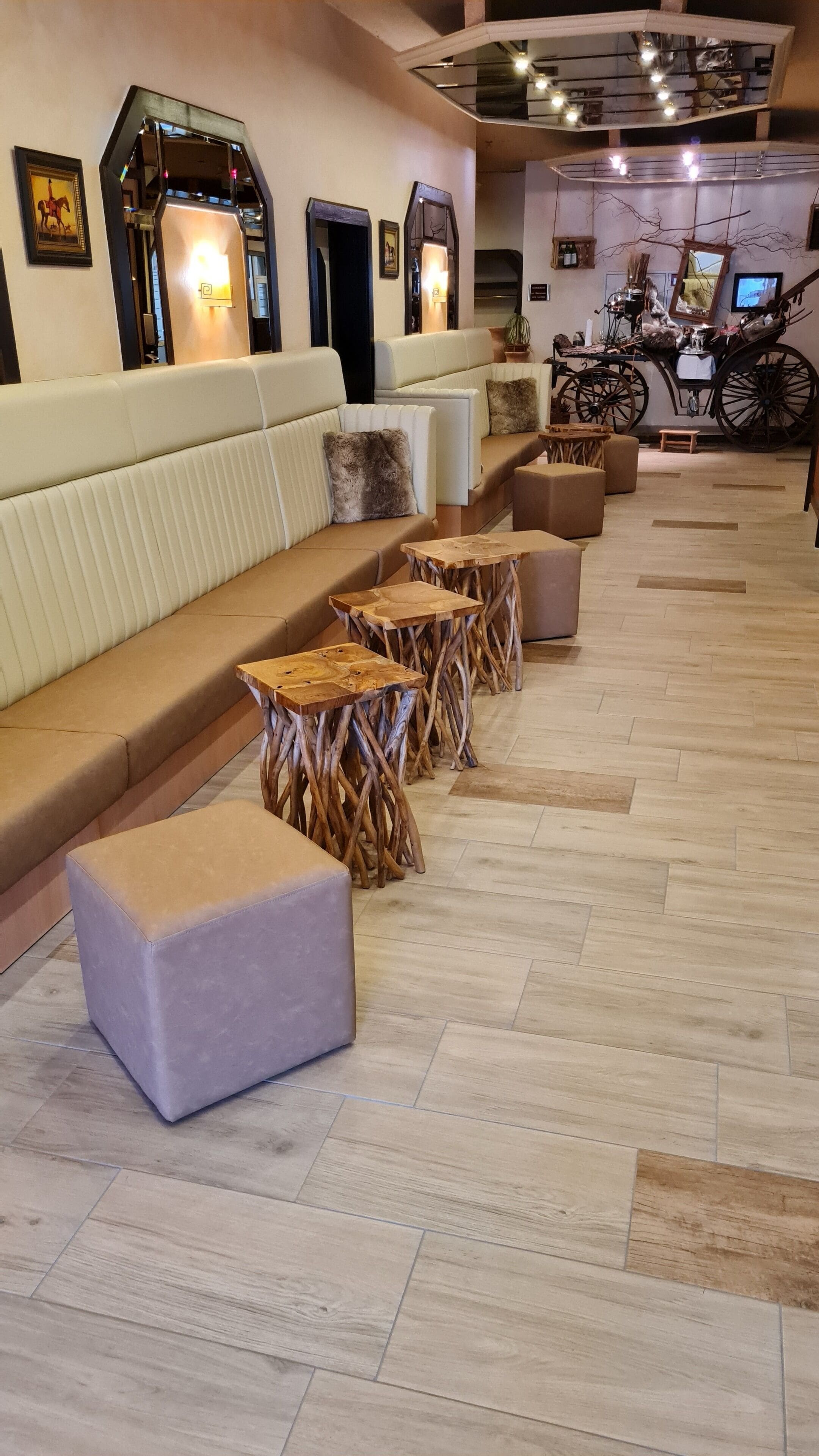 A modern lounge area with a sofa, wooden stools, and a bench.