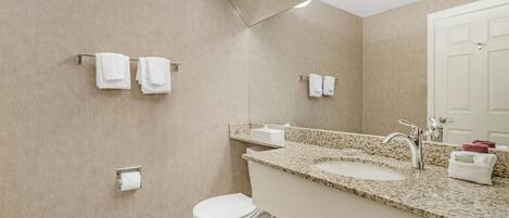 Un baño moderno con inodoro, lavamanos y perchero para toallas.