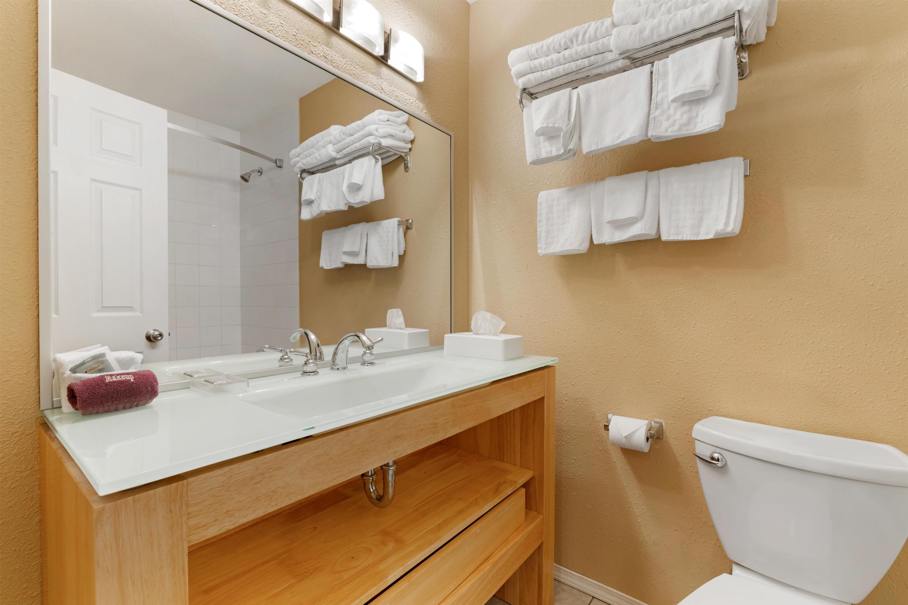 Une salle de bain avec un lavabo blanc, un miroir et un porte-serviettes.