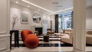 A modern living room with a fireplace, comfortable seating, and a view of the city.