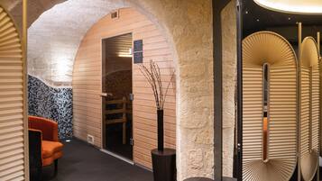 A spa area with a wooden bench, a massage table, and a wall with a textured pattern.