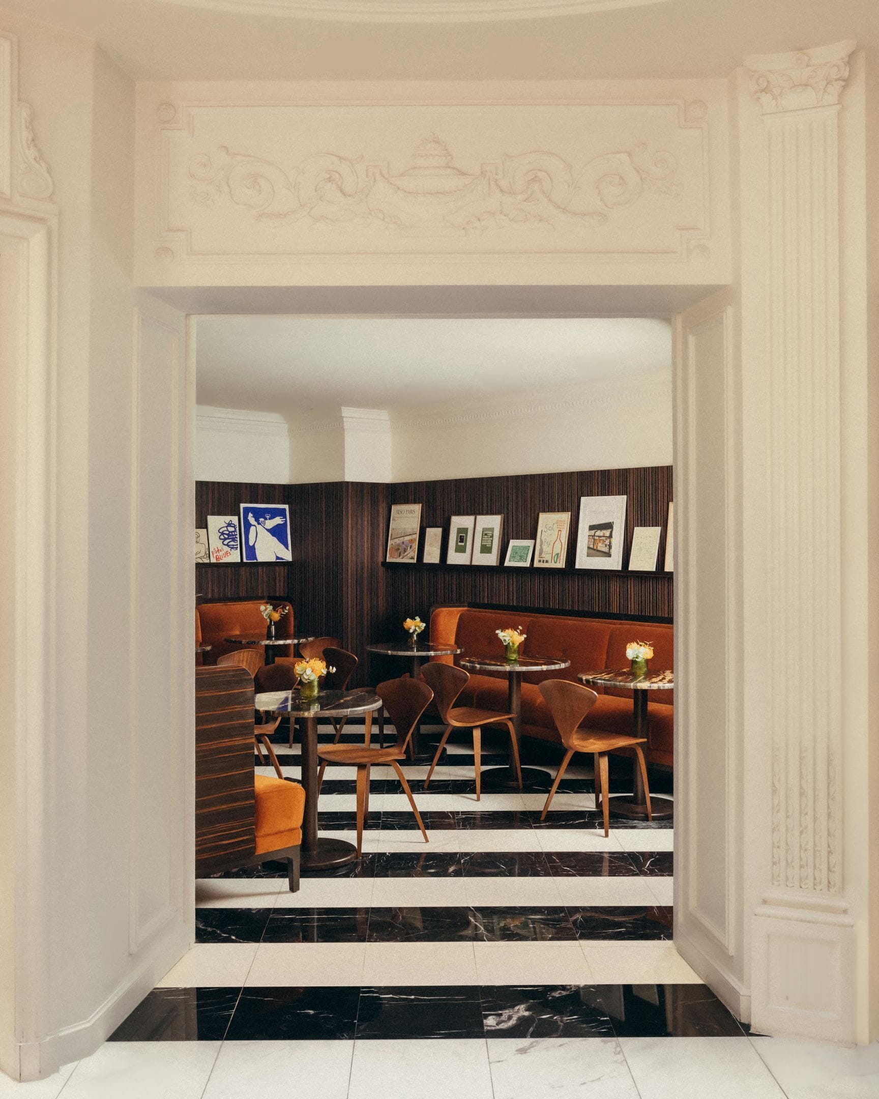 A lobby with a marble floor, a reception desk, and a seating area with tables and chairs.
