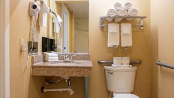A bathroom with a toilet, sink, towel rack, and hairdryer.