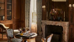 Une pièce de style traditionnel, dotée d’une cheminée, de meubles en bois richement décorés et d’un lustre.