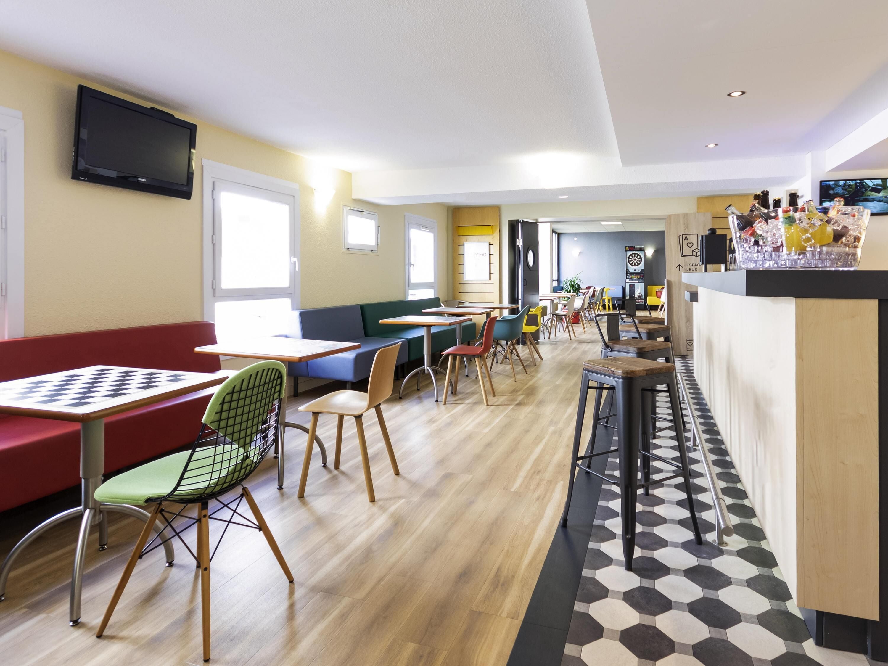 Un restaurant moderne avec des tables hautes, des sièges confortables et un espace bar.