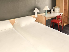 A hotel room with a bed, a desk, a chair, and two lamps. - ibis Rochefort (Rochefort)