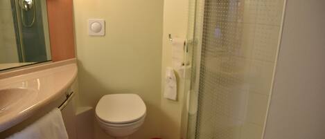 Un baño con lavamanos, inodoro y ducha.