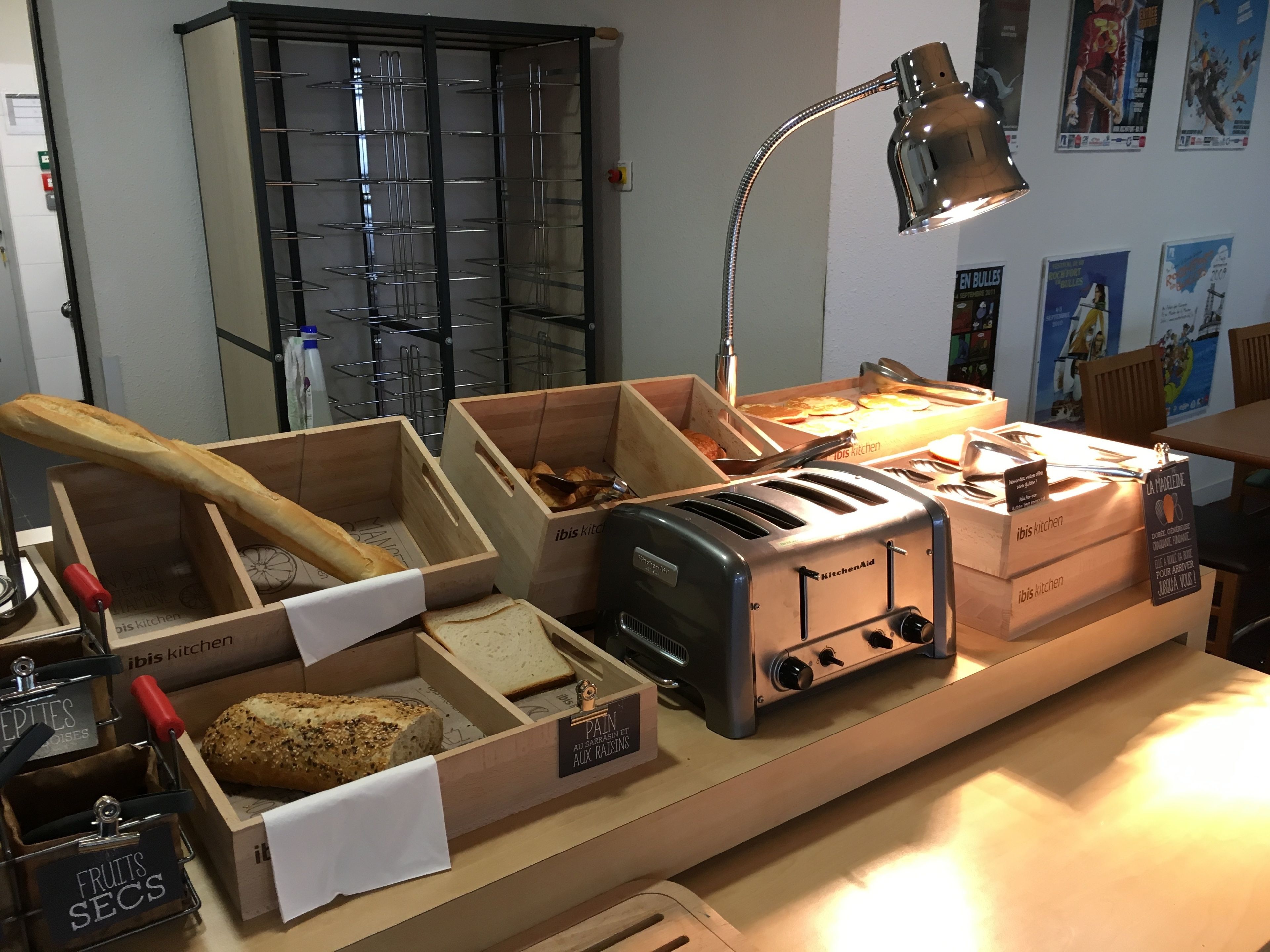 A kitchen counter with various food items and kitchen appliances, including a toaster and a bread box.