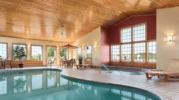An indoor swimming pool with wooden ceiling, tiled floor, and large windows. - Country Inn & Suites by Radisson, Baxter, MN (Brainerd)