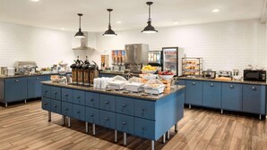 A modern kitchen with blue cabinets, a granite countertop, and stainless steel appliances. - Country Inn & Suites by Radisson, Baxter, MN (Brainerd)