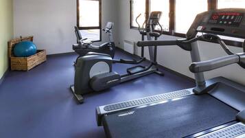 A gym with exercise equipment, a treadmill, and a stationary bike.