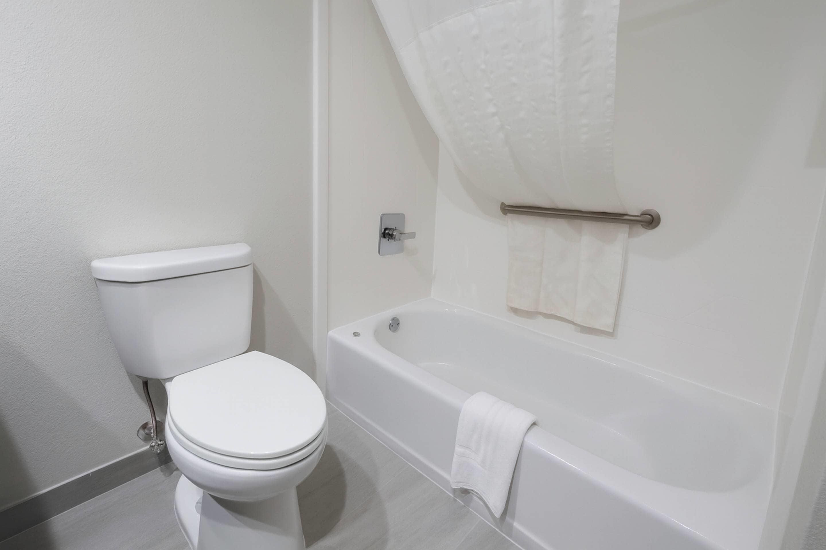 Ein Badezimmer mit Toilette, Badewanne und Duschvorhang.