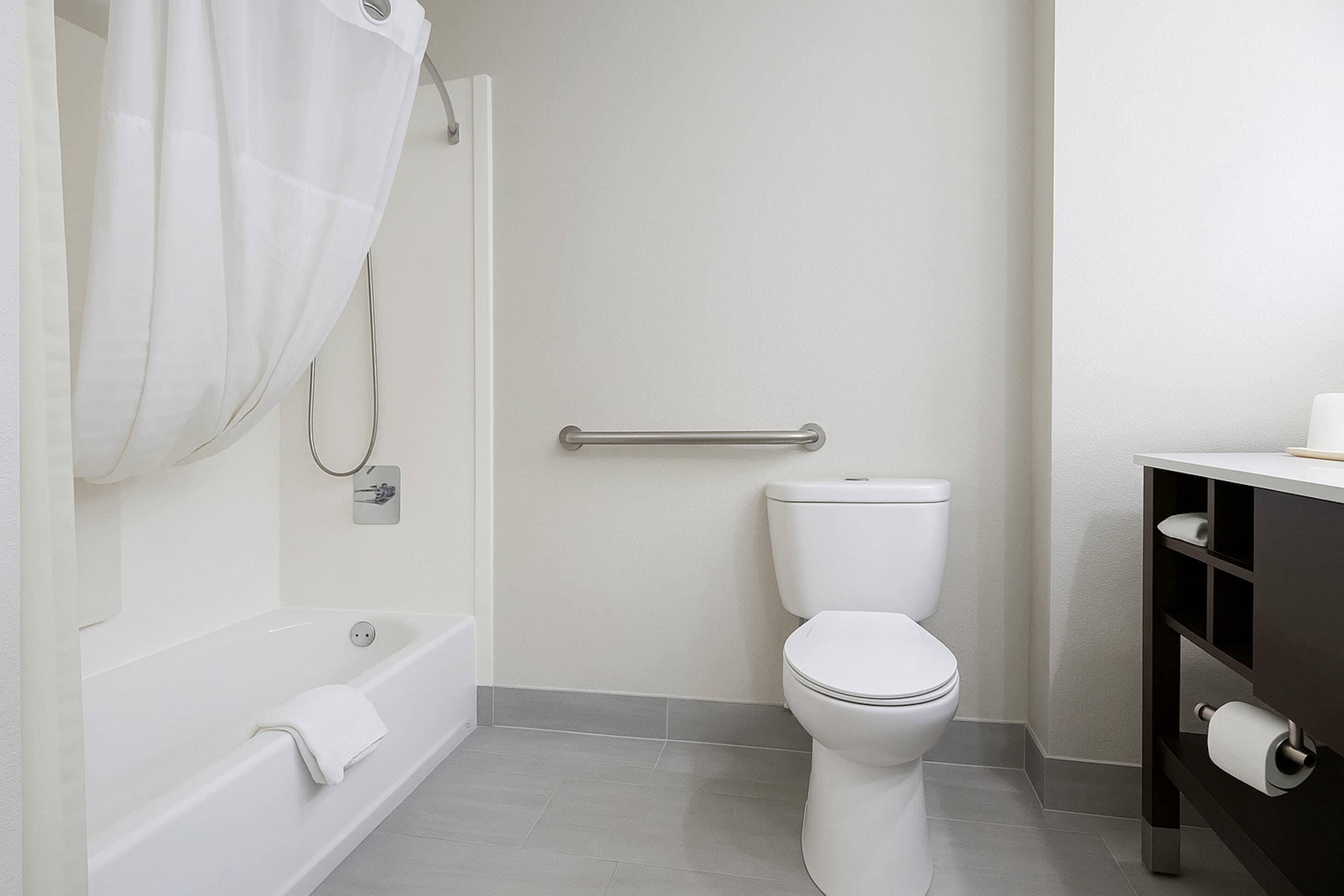 Une salle de bain avec une baignoire, des toilettes et un porte-serviettes.
