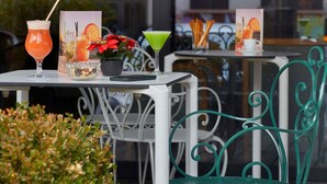Un espacio al aire libre con mesas, sillas y diferentes bebidas.