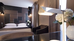 Una habitación de hotel moderna con una cama grande, un escritorio y una silla.