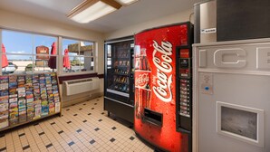 A vending area with Coca-Cola and a magazine rack, a window with a view, and a vending machine with a Coca-Cola logo. - Kings House Motor Hotel, a Dazzler Select by Wyndham (Flagstaff)