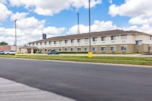 A Comfort Inn hotel with a two-story structure, a parking lot, and a clear sky.