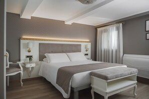 A modern hotel room with a large bed, bedside tables, a chair, and a bench. - Hotel Montecarlo (Venice)