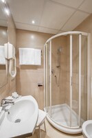 Un bagno moderno con doccia vetrata, lavabo bianco e specchio.