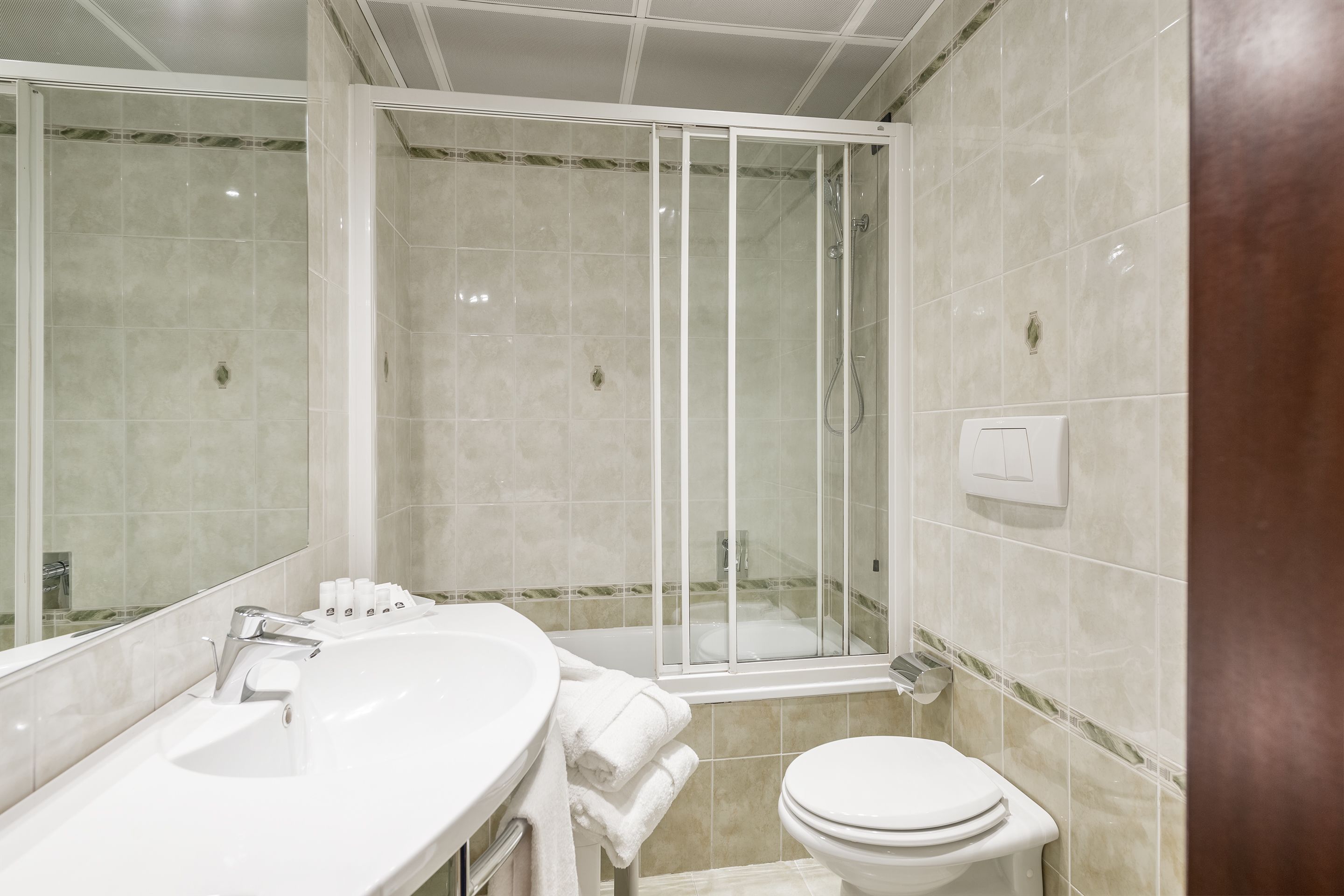 Un bagno moderno con doccia vetrata, lavandino bianco e water.