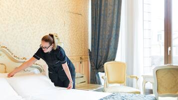 Een hotelkamer met een bed, een stoel en een raam met gordijnen.