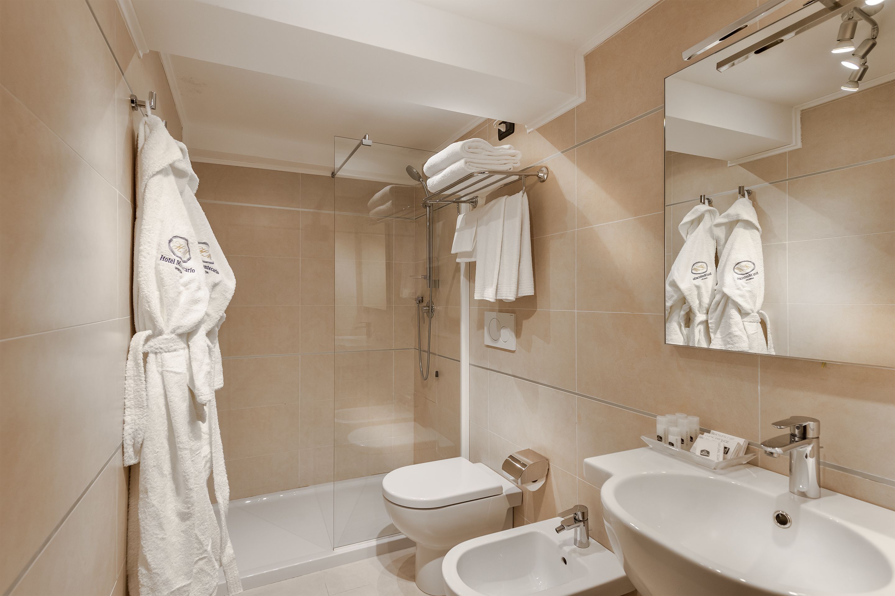 Un bagno moderno dotato di vasca, WC, bidet e un ampio specchio.