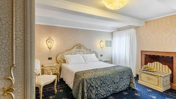 A bedroom with a large bed, a chair, a dresser, and a fireplace.