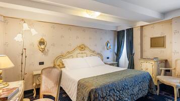 Ein Hotelzimmer mit einem großen Bett, einem Sessel, einem Schreibtisch und einem Spiegel.