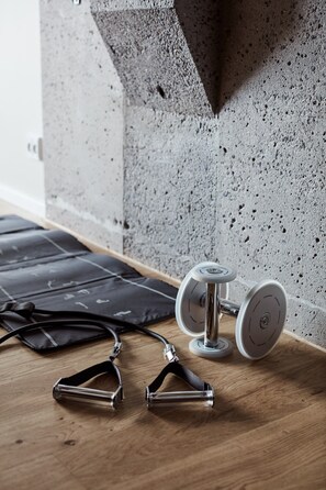 A concrete wall with a textured surface and a wooden floor.
