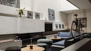 Un intérieur moderne agrémenté d’une cheminée, de coins salon et d’œuvres d’art aux murs.