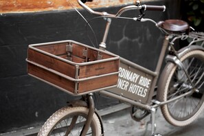 A bicycle with a wooden box attached to the front, and a sign on the side that reads 'ORDINARY RIDE INER HOTELLS'.