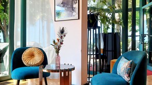 Een moderne woonkamer met twee blauwe fauteuils, een ronde salontafel en een ingelijste foto aan de muur.