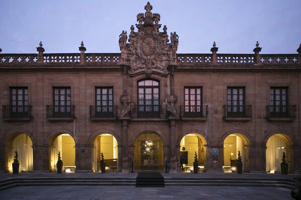 A historic building with ornate architecture, featuring multiple arched doorways and a central entrance.