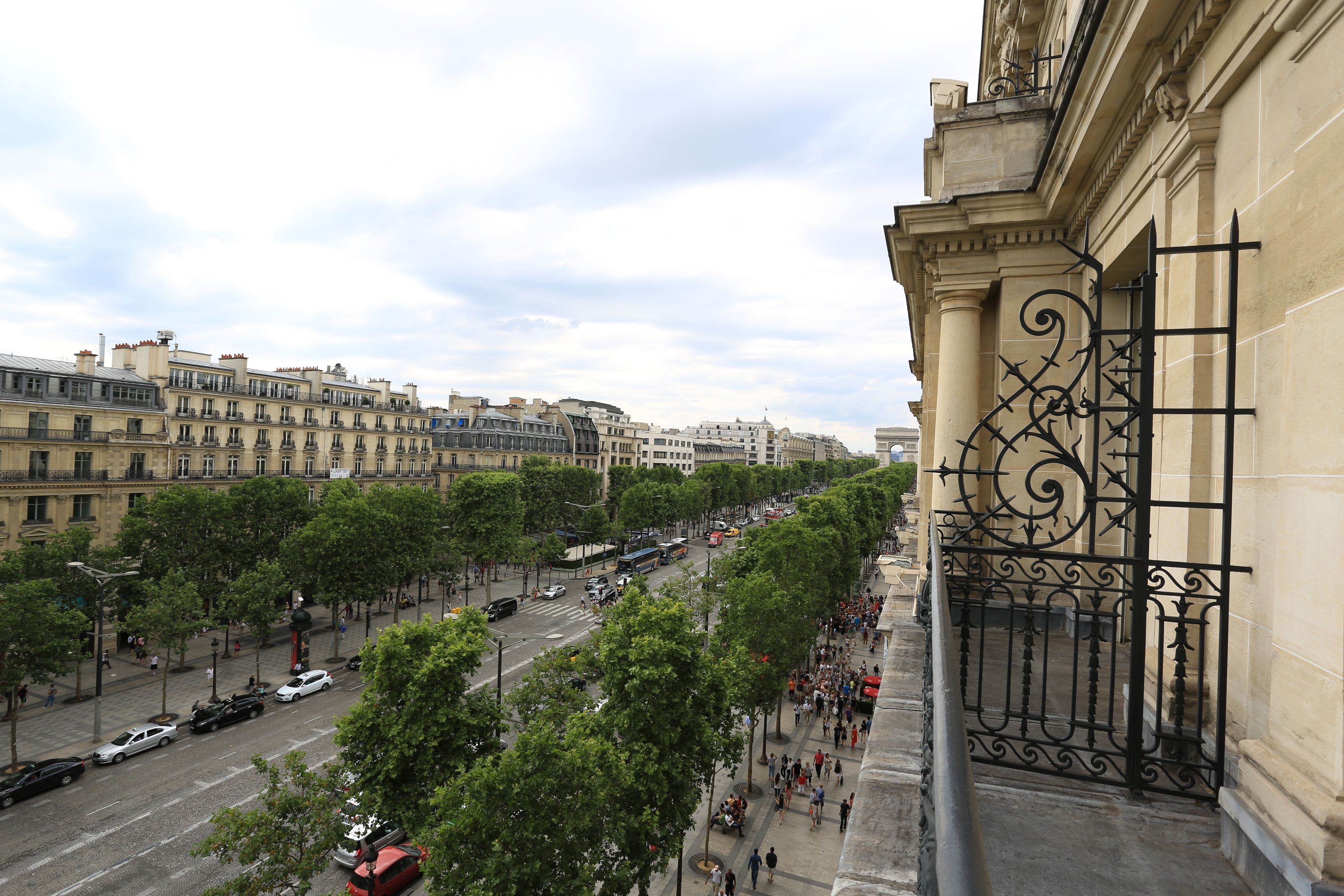 Vista de la calle con edificios, árboles y una transitada vía.