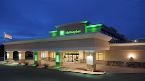 A Holiday Inn hotel with a modern facade, a prominent sign, and a well-lit entrance.